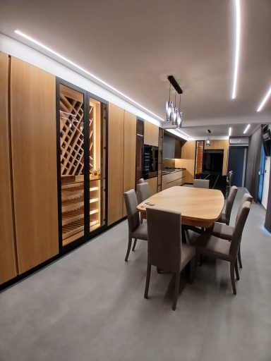 Interno di una sala da pranzo moderna con tavolo e cantina per vini integrata.